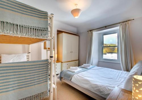 a bedroom with a bunk bed and a window at Monicas House 8 Porthmeor Square in St Ives