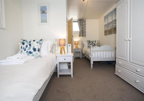 um pequeno quarto com uma cama e uma cadeira em 38 Pier View em St Ives
