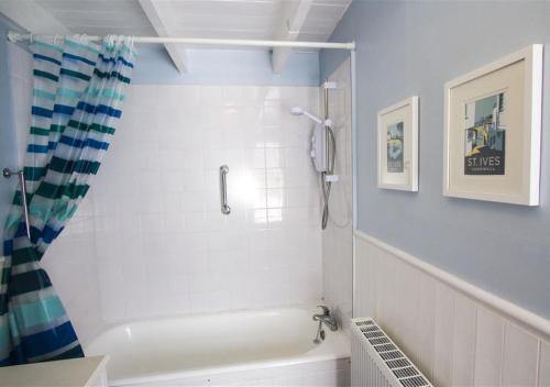 uma casa de banho com um chuveiro e uma banheira em 38 Pier View em St Ives