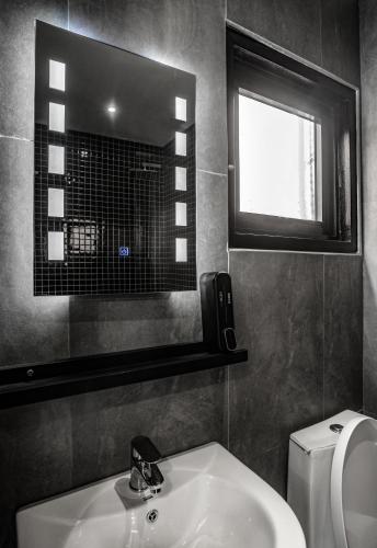 a bathroom with a sink and a window and a toilet at Boxo Diani - Unique Beach Front Container Eco-Hotel in Diani Beach