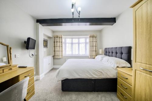 a bedroom with a bed and a television in it at Victoria Lodge in Kenilworth