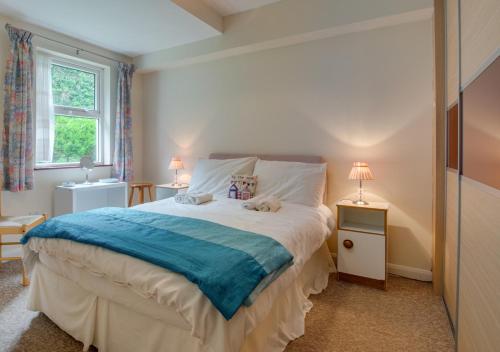 um quarto com uma cama grande e um cobertor azul em Seacroft 6 Carthew Court em St. Ives