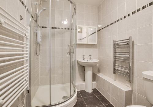 uma casa de banho com um chuveiro, um lavatório e um WC. em Seacroft 6 Carthew Court em St. Ives