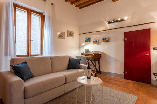a living room with a couch and a red door at La sosta di Arrigo in Buonconvento