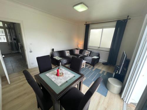 un salon avec un canapé, une table et des chaises dans l'établissement Balcon St Raymond maison 100m2 centre Lourdes, à Lourdes