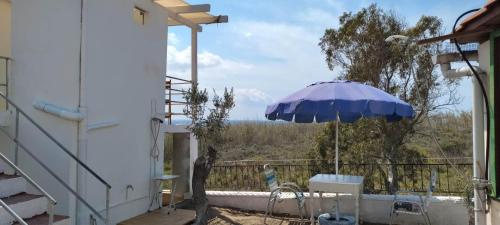 a patio with an umbrella and a table and chair at Peristeronas in Liaropá