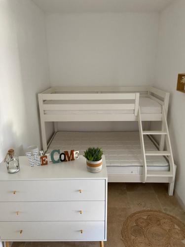 - une chambre avec des lits superposés blancs et une commode blanche dans l'établissement Proche SARLAT le gîte de FANOVA, à Marcillac-Saint-Quentin