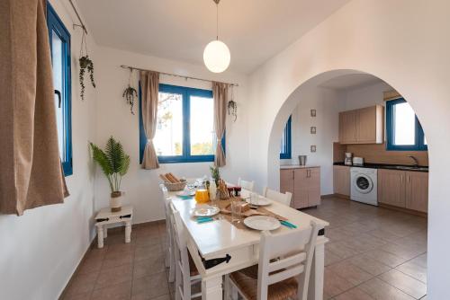 a kitchen and dining room with a white table and chairs at Blue Sea Villa in Gennadi