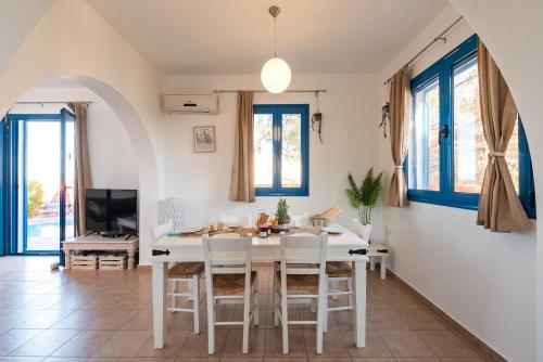 cocina y comedor con mesa blanca y sillas en Blue Sea Villa, en Gennadi