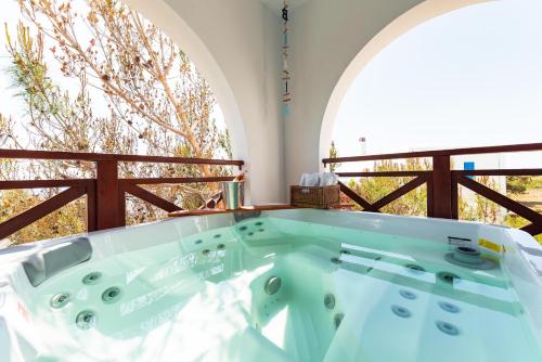 a bathroom with a tub with two sinks in it at Blue Sea Villa in Gennadi