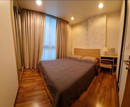 um quarto com uma cama, uma secretária e uma janela em Free Airport Pick up ,1 BR 4 mins from BTS Ekkamai em Klong Toi