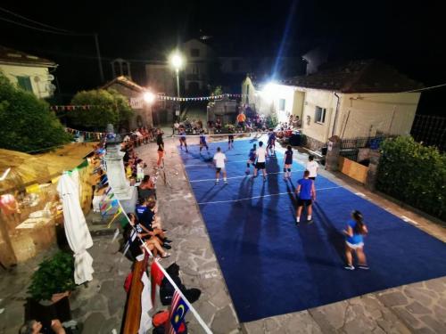 a group of people playing a game of volleyball at night at La Casetta in Montefegatesi