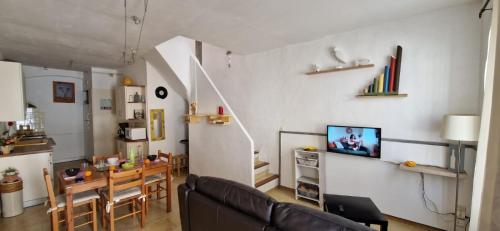 - un salon avec un canapé et une salle à manger dans l'établissement Maison PORTIRAGNES près de la mer et du Canal du Midi, à Portiragnes