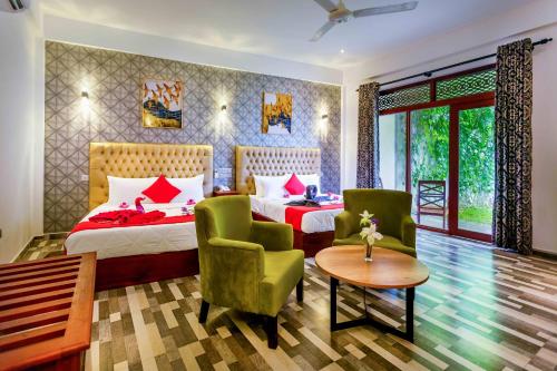 Polhena Grand Resort & Banquet في ماتارا: غرفة فندقية بسريرين وطاولة وكراسي