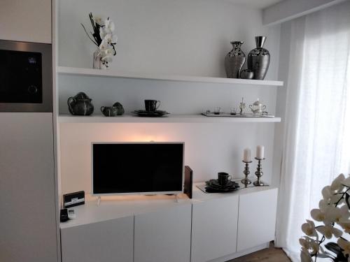 a living room with a tv on a white entertainment center at PEARL HOUSE in Aveiro