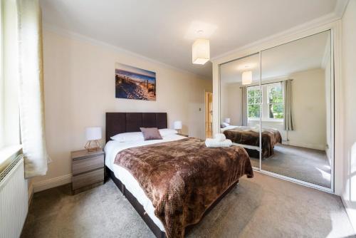 a bedroom with a large bed and a large mirror at Terrific 2 Bed 2 Bath Apt with gym & roof terrace -12 mins from Central London in London