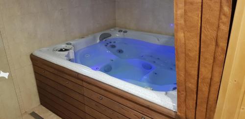 a blue tub in a bathroom with a wooden cabinet at Vila Jedľa in Smokovce