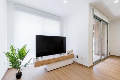 a living room with a flat screen tv on a white wall at Apartamento Sunrise Chapaprieta in Torrevieja