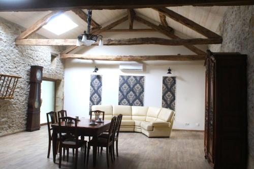 een woonkamer met een bank, een tafel en stoelen bij Gîte - La Couderquié in Lautrec