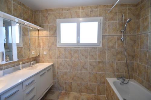 a bathroom with a tub and a sink and a tubermottermott at Villa berges landaises location vacances spacieuse Villa avec piscine chauffée capbreton in Capbreton