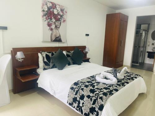 a bedroom with a bed with two swans on it at Hotel Catama Inn in Fusagasuga