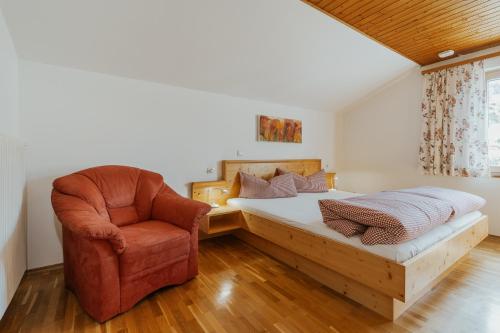 - une chambre avec un lit et une chaise dans l'établissement Berghof Latzer, à Gurtis