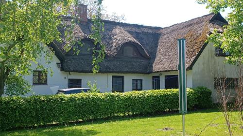 a white house with a shingled roof at FW Im grünen Weg in Wustrow