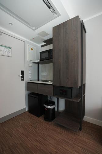 a room with a desk and a cabinet with a microwave at Boutique Kaiser - Hotel & Apartments in Frankfurt/Main