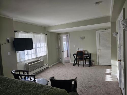 a room with a bed and a television and a desk at Lowell Inn in Stillwater
