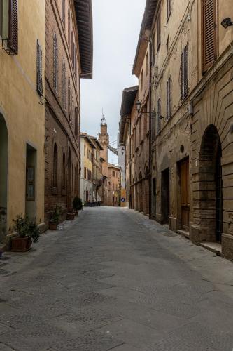 an empty street in an alley between buildings at La sosta di Arrigo in Buonconvento