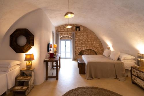 a bedroom with two beds and a stone wall at Masseria Soluco in Monopoli