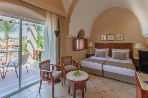a hotel room with a bed and a balcony at Iberotel Makadi Beach in Hurghada