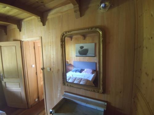 einen Spiegel an der Wand mit einem Bett in einem Zimmer in der Unterkunft gite des 3 cazelles in Cajarc