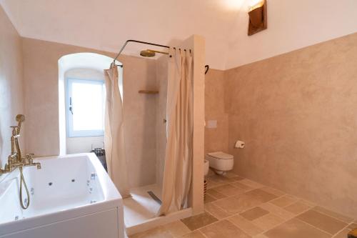 a bathroom with a bath tub and a toilet at Masseria Soluco in Monopoli