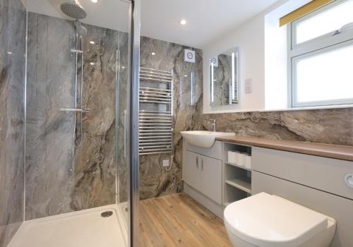 a bathroom with a shower and a toilet and a sink at Old Coastguard Station in Dunbar