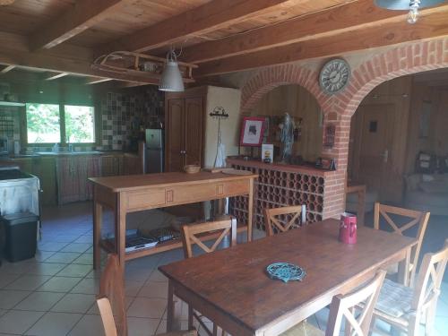uma cozinha com duas mesas de madeira e uma parede de tijolos em gite des 3 cazelles em Cajarc