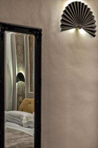 a mirror with a fan on the wall next to a lamp at Ancona e Riviera Luxury b&b in Ancona