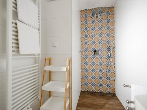 a small closet with white shelves and a patterned wall at Ferienhaus Sporr in Herrnbaumgarten