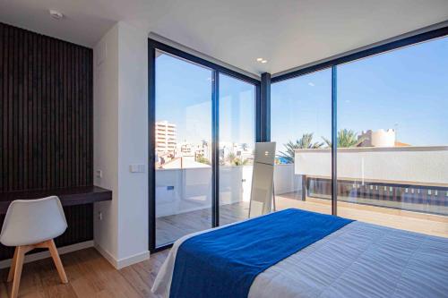 Schlafzimmer mit einem Bett und großen Glasfenstern in der Unterkunft Inmovecos Villa Gawy 2 de Lujo con piscina privada in La Manga del Mar Menor