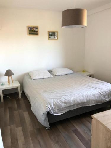 une chambre avec un lit, une table et une lampe dans l'établissement Gite Ecuries Vineuil Jump, à Vineuil