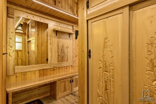 a bathroom with wooden walls and a mirror at Apartament Zakopane utrzymany w stylu góralskiej chaty in Zakopane