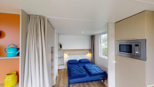 a small bedroom with a bunk bed and a tv at Villapark de Paardekreek in Kortgene