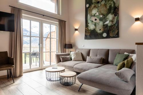 a living room with a couch and a table at Tauernlodges Uttendorf by ALPS RESORTS in Uttendorf