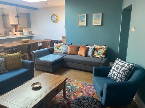 uma sala de estar com um sofá, cadeiras e uma mesa em 55 High Street em Hastings