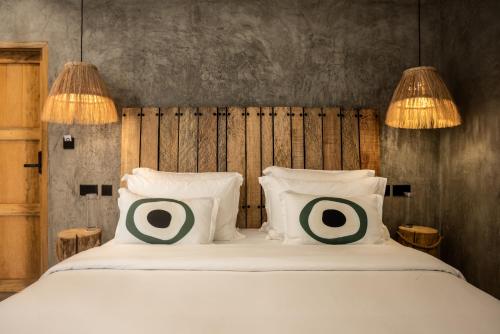 a bedroom with a bed with two pillows on it at LalaGalu - Beachfront EcoCabins in Diani Beach