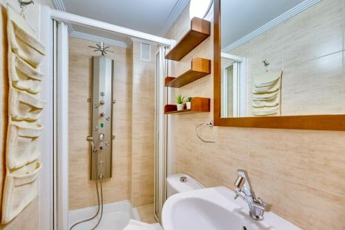 een badkamer met een wastafel, een douche en een spiegel bij VB Marysol - 2BR apartment close to the beach in Benalmádena