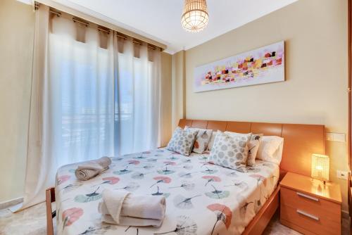 sypialnia z łóżkiem i dużym oknem w obiekcie VB Marysol - 2BR apartment close to the beach w mieście Benalmádena