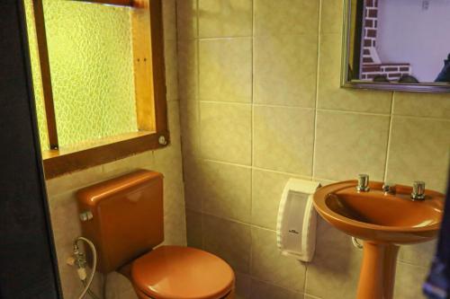 a bathroom with a toilet and a sink at Hotel da Inês in Visconde De Maua