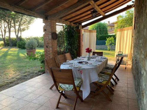 einen Tisch mit einem weißen Tischtuch auf einer Terrasse in der Unterkunft CASA INDIPENDENTE con giardino in Castiglione del Lago