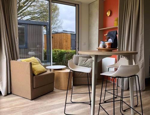 a living room with a table and a chair at Villapark de Paardekreek in Kortgene